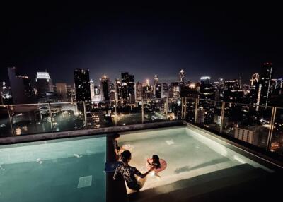 Night city skyline view from rooftop pool area