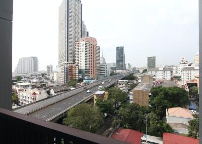 View of the cityscape from the balcony showing high-rise buildings and a highway