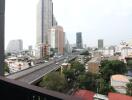 View of the cityscape from the balcony showing high-rise buildings and a highway