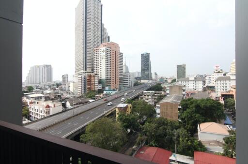 View of the cityscape from the balcony showing high-rise buildings and a highway