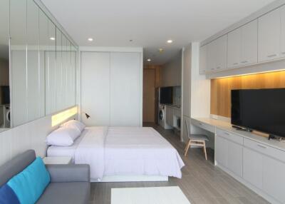 Modern bedroom with integrated workspace and large TV
