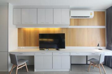 Modern living area with a TV, desk, and chairs