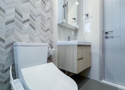 Modern bathroom with toilet, vanity, and mirror