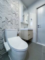 Modern bathroom with toilet, vanity, and mirror