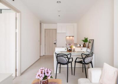 Modern dining area with table, chairs, and kitchen in contemporary apartment