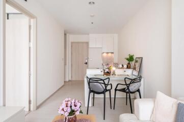 Modern dining area with table, chairs, and kitchen in contemporary apartment