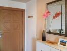 Entrance hallway with a wooden door, mirror, and decor