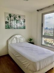 Bright bedroom with a single bed and a large window