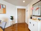 Minimalist entryway with wooden floor, a wall mirror, and decorative items