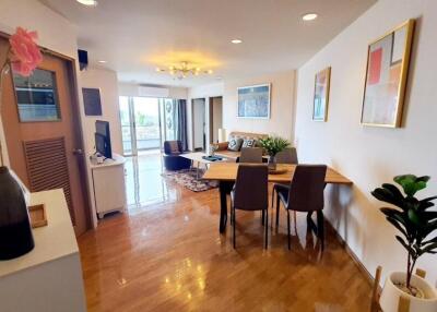 Modern living room with wooden floors, a dining area, and decorative elements