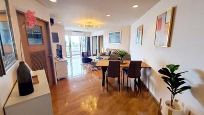 Modern living room with wooden floors, a dining area, and decorative elements