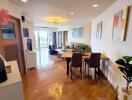 Modern living room with wooden floors, a dining area, and decorative elements