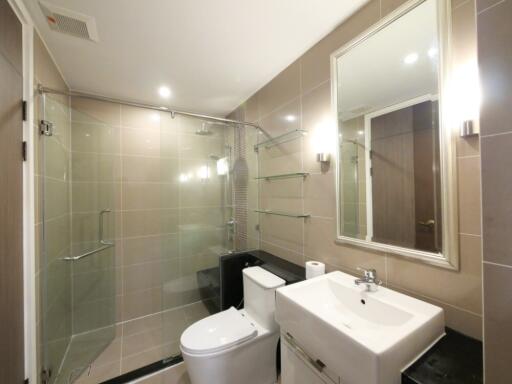 Modern bathroom with glass shower, toilet, and sink