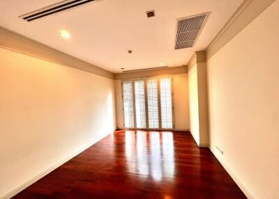 Empty room with wooden floor and large windows