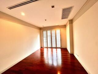 Empty room with wooden floor and large windows