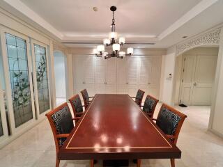 Elegant dining room with a large wooden table and cushioned chairs