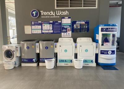 Laundry room with various washing machines and dryers at Trendy Wash innovative laundromat.