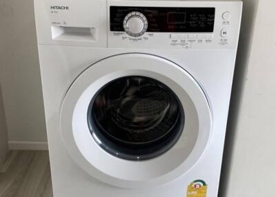 Front-load Hitachi washing machine in a laundry area