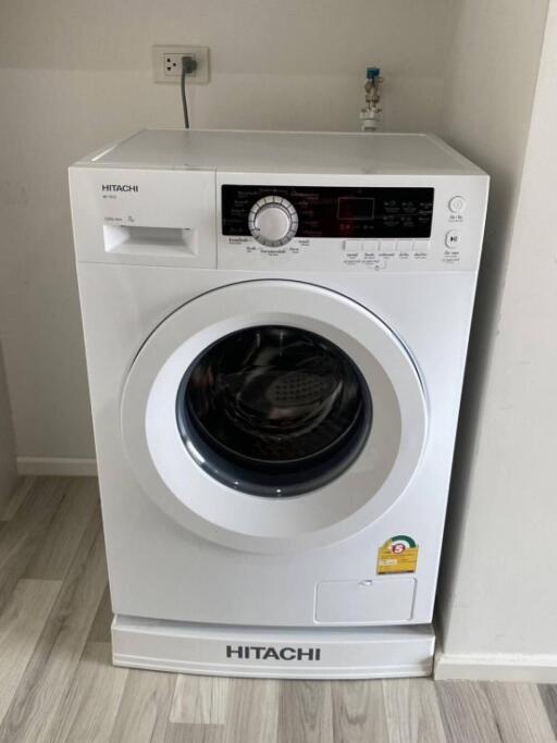 Front-load Hitachi washing machine in a laundry area