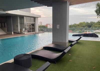 Outdoor pool area with lounge chairs and city view