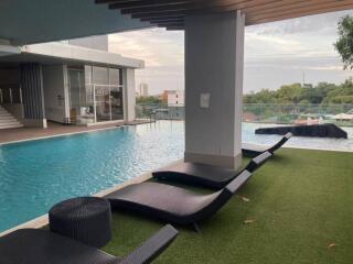 Outdoor pool area with lounge chairs and city view