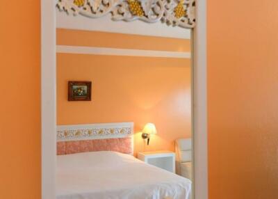 Bedroom with orange walls and decorative headboard