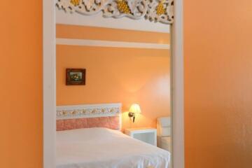 Bedroom with orange walls and decorative headboard