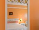 Bedroom with orange walls and decorative headboard