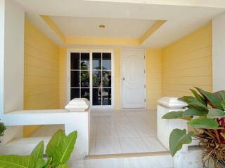 Front entrance with plants and yellow siding