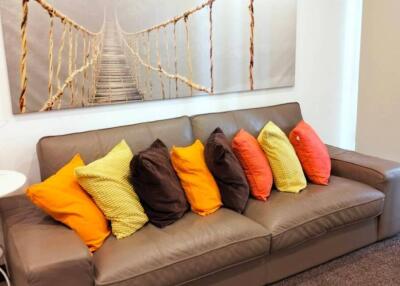 Living room with a grey couch and colorful pillows