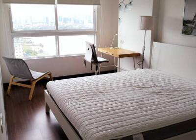 Bedroom with large window and city view