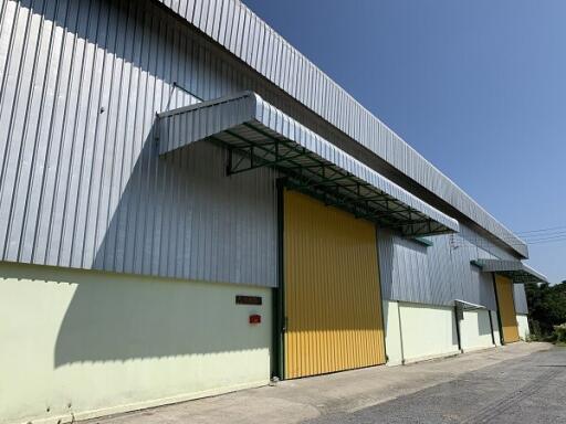 Large warehouse with yellow doors and metal siding