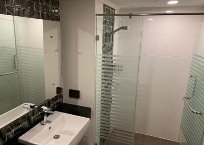 Modern bathroom with glass shower enclosure and sleek fixtures