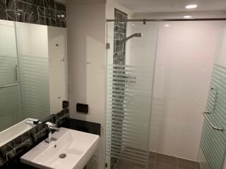 Modern bathroom with glass shower enclosure and sleek fixtures