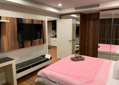 Modern bedroom with TV and pink bedspread