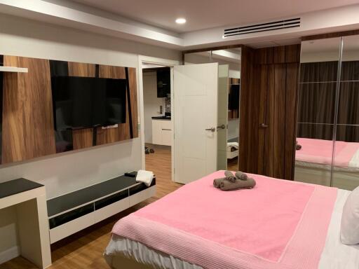 Modern bedroom with TV and pink bedspread