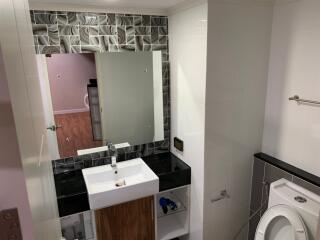 Modern bathroom with sink, mirror, and toilet