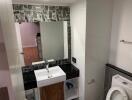 Modern bathroom with sink, mirror, and toilet