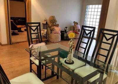 Modern dining area with glass table and cushioned chairs