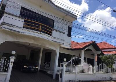 Exterior view of a house with carport and balcony