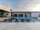 Modern outdoor pool area with lounge chairs and surrounding seating space