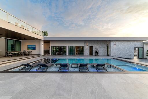 Modern outdoor pool area with lounge chairs and surrounding seating space