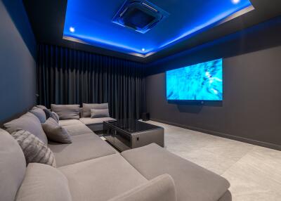 Home theater with gray sectional sofa and blue LED ceiling lights
