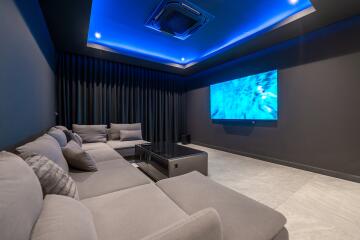 Home theater with gray sectional sofa and blue LED ceiling lights