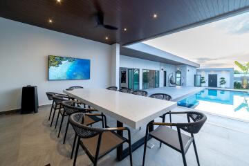 Covered outdoor dining area next to a pool