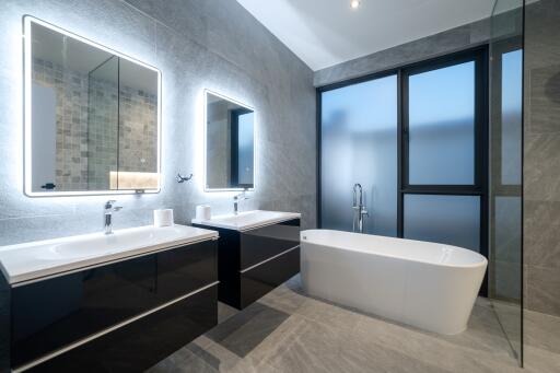 Modern bathroom with twin mirrors and freestanding bathtub