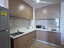 Modern kitchen with wooden cabinets, stainless steel appliances, and white countertops.