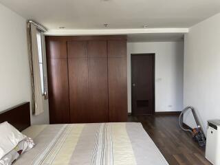 Bedroom with wooden wardrobe, bed, and window