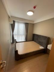 Bedroom with large window and upholstered bed