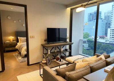 Modern living room with a view of the city and access to a bedroom